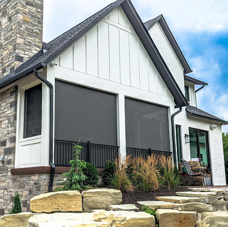 ShadeFX retractable screens integrated into the framed porch openings of a gabled residence.